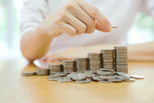 woman put coins to stack of coins