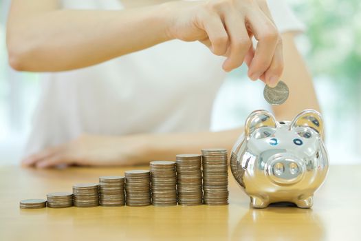 saving money-young woman putting a coin into a money-box-close up