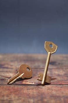 Door key standing on wooden board against dark background