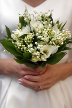 The bride holds a wedding bouquet