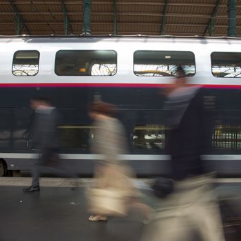 Subway train at the station. People coming to or leaving train station platform. Motion blur. City life.