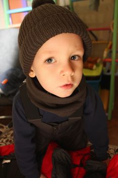Winter baby. Little boy dressed in warm clothing at home. How to dress baby for the weather