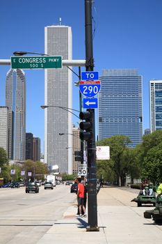 A busy Chicago Street near Grant Park with skyscrapers in background.
