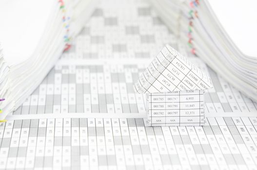 Close up house on finance account have pile of document with colorful paperclip as background.