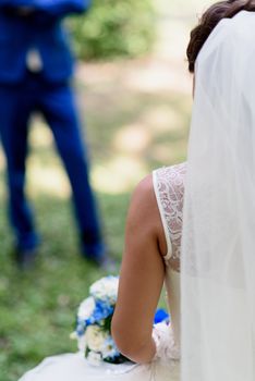 bride holding a bouquet with blue flowers in her hands