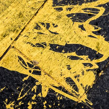 Abstract Background Tecture Of Yellow Paint Spilled On Black Tarmac