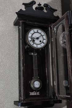 old mechanical clock hanging on the wall