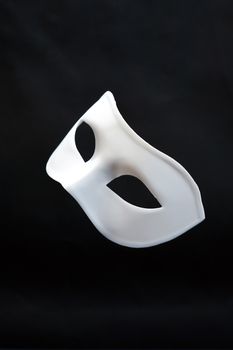 Theater concept. Closeup of white classical carnival mask on dark