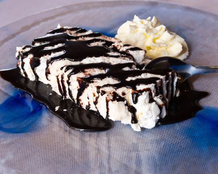 Meringue with chocolate and cream on plate at restaurant,close-up.