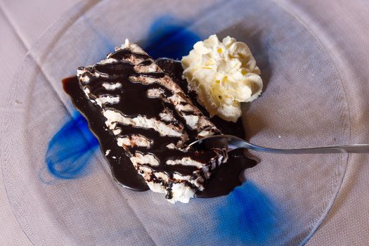 Meringue with chocolate and cream on plate at restaurant,from above.