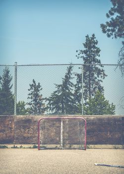 Retro Style Image Of Grungy Empty Neighborhood Hockey Net Plus Stick