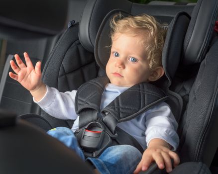 Infant boy 8 months old in a safety car seat.