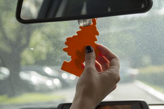 Arm girls with trendy manicure keeps air freshener in your car.