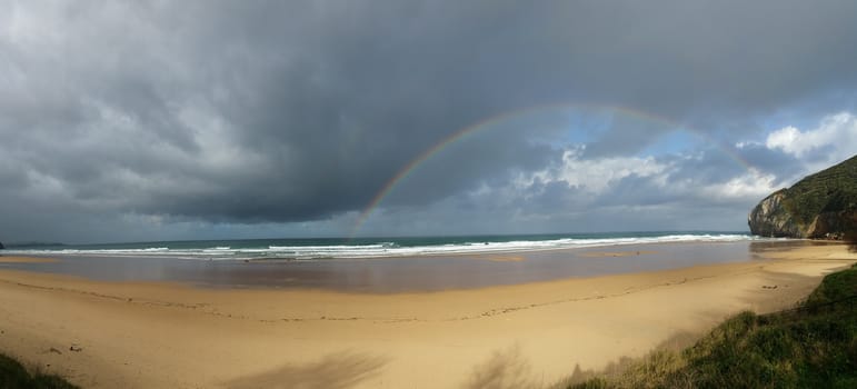 rainbow on the beach, cloudy morning