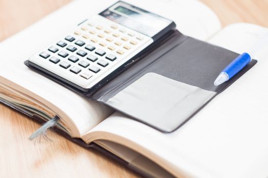 Classic leather notebook with pen and calculator, stock photo