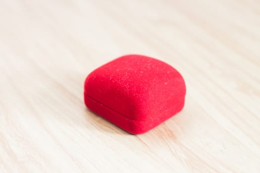 Red ring box on wooden background, stock photo