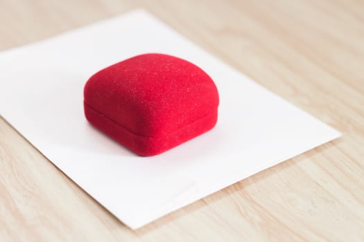 Red ring box on wooden background, stock photo