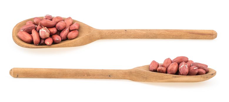 Raw peanuts on wooden spoon isolated on white. Selective focus.