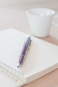 Pen and spiral notebook with coffee cup, stock photo