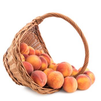 Basket full of fresh peaches isolated on white background. Selective focus.