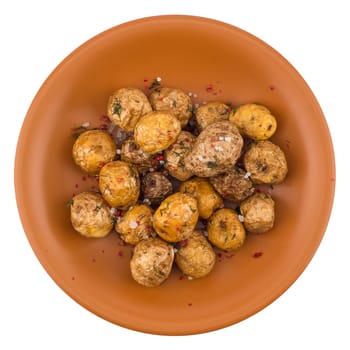 Baked potatoes with spices in a ceramic plate. Top view.