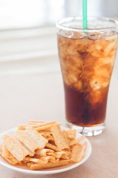 Snack on white plate with a glass of cola , stock photo