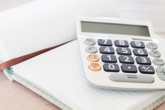 Calculator on blank notebook, stock photo