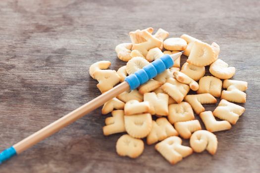 Alphabet biscuit on wooden table, stock photo