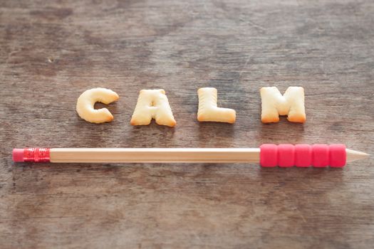 Calm alphabet biscuit on wooden table, stock photo