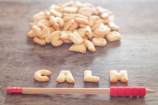 Calm alphabet biscuit on wooden table, stock photo