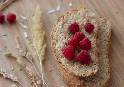 bread raspberries and ears on wooden table