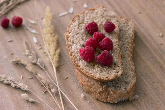 bread raspberries and ears on wooden table