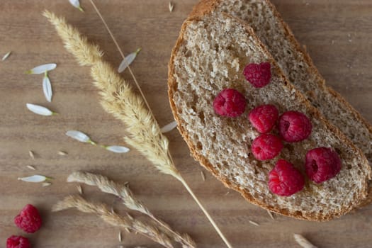 bread raspberries and ears on wooden table