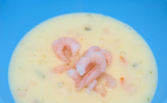 Fish soup with shrimps in the blue bowl