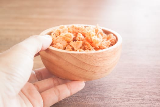 Fried shrimp chins snack in wooden bowl, stock photo