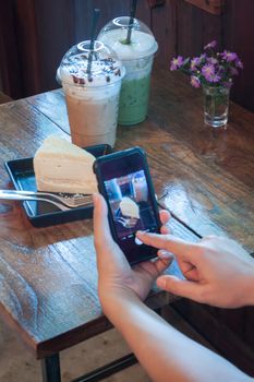 Closeup woman using smartphone in coffee shop, stock photo