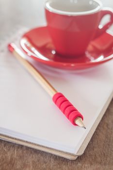 Red mug with open notebook, stock photo