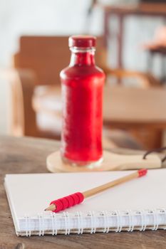 Red syrup in the bottle on wooden plate, stock photo