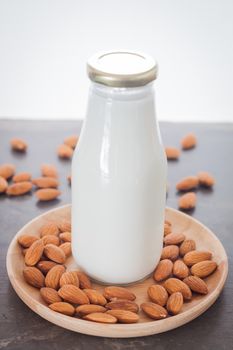 Almond nuts on wooden plate with milk, stock photo