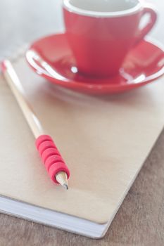 Red mug with open notebook, stock photo