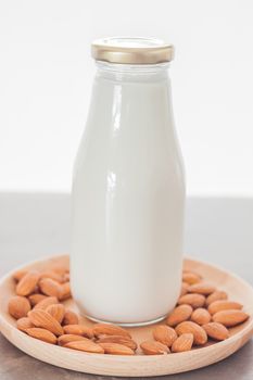 Almond nuts on wooden plate with milk, stock photo