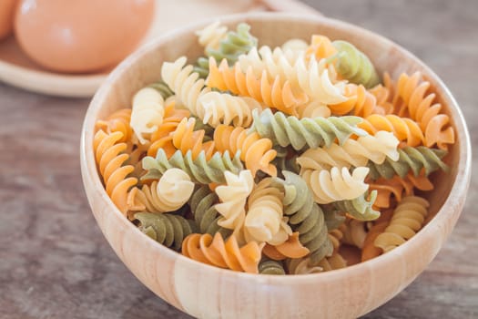 Fusili pasta in wooden plate with eggs, stock photo