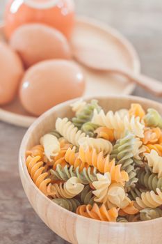 Fusili pasta in wooden plate with eggs, stock photo