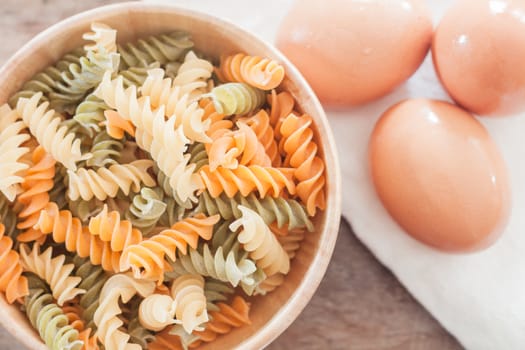 Fusili pasta in wooden plate with eggs, stock photo