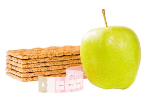 Measuring tape, crispbread and delicious green apple isolated on white. Diet or healthy eating concept.