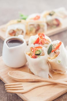 Fresh spring rolls on wooden table, stock photo