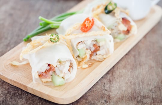 Fresh spring rolls on wooden table, stock photo
