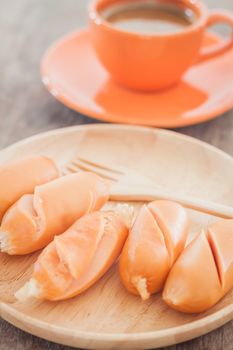 Chicken sausages on wooden plate, stock photo