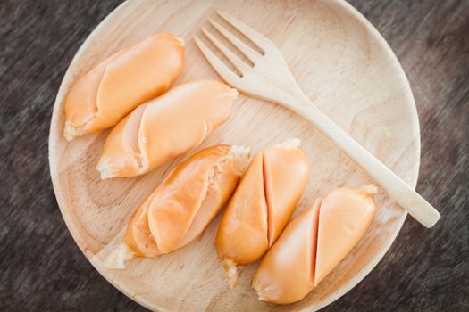 Chicken sausages on wooden plate, stock photo