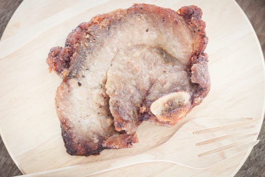Pork steak on wooden plate, stock photo
